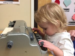 Little girl using a braille writer.