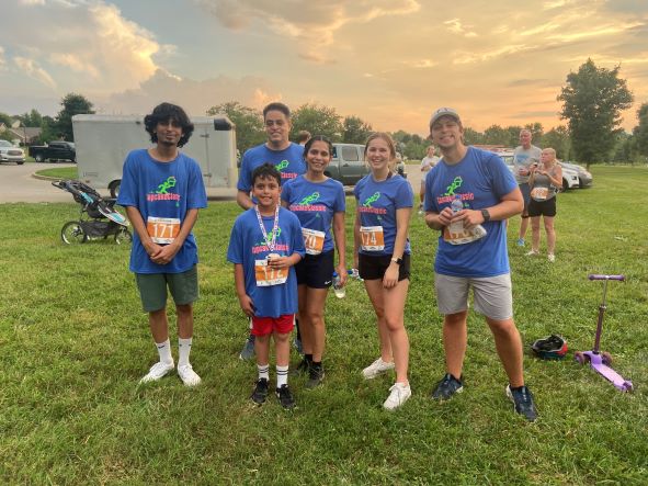 Group of runners with race medals smiling.