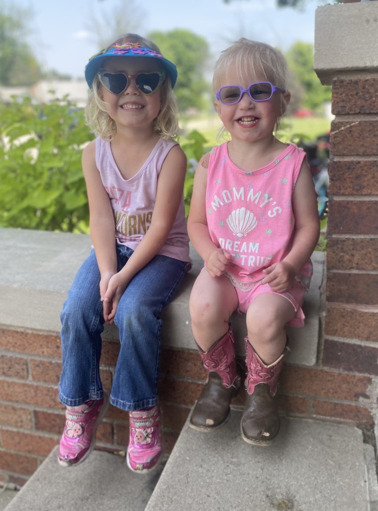 Avelyn and her sister smiling on the steps