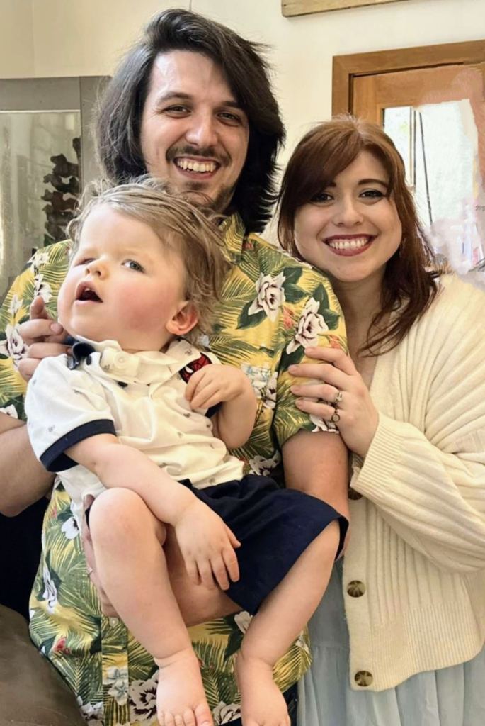 Father and mother holding their son in front of them, smiling