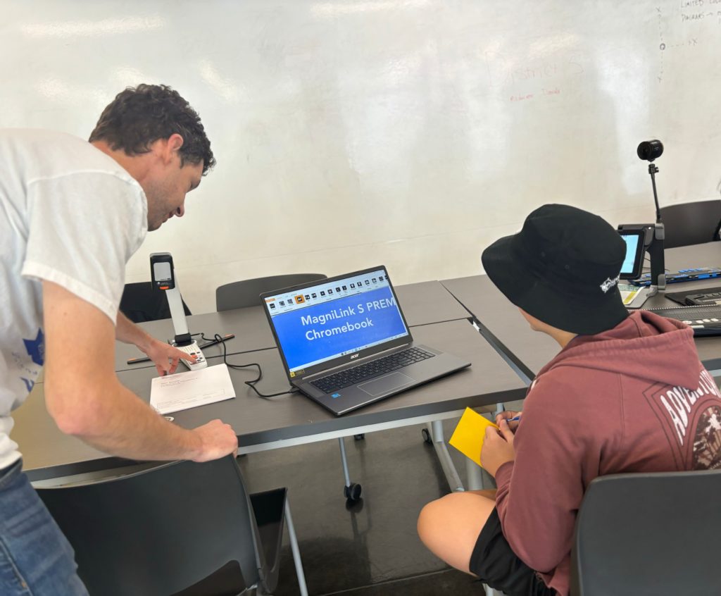 Student and adult looking at a laptop