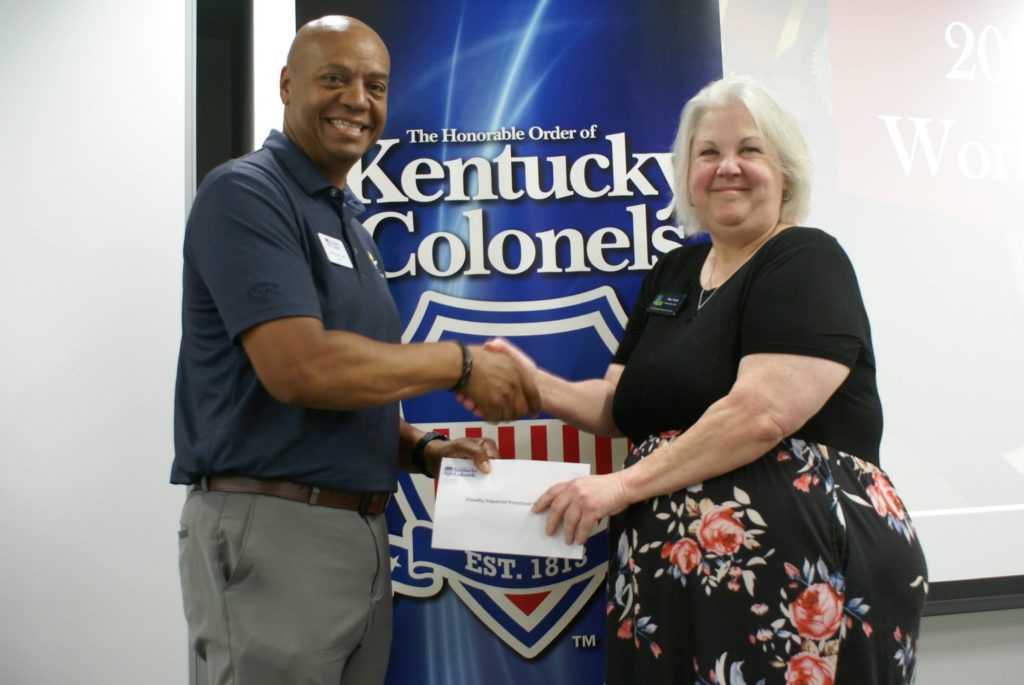 General Alex Lyttle (left) presents Mary Smyth of VIPS (right) with a $4,999.95 grant.