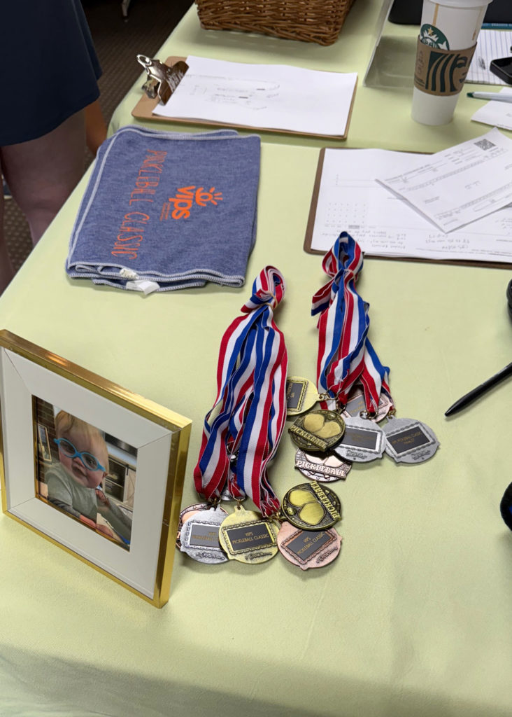 Pickleball tournament medals displayed on the registration table.