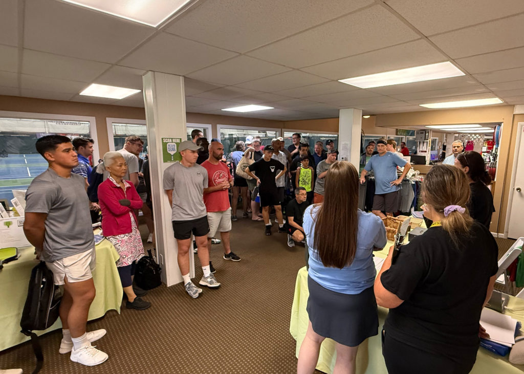 Pickleball tournament players gather to hear the results form their match.