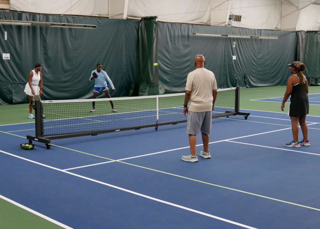 Pickleball doubles teams playing.
