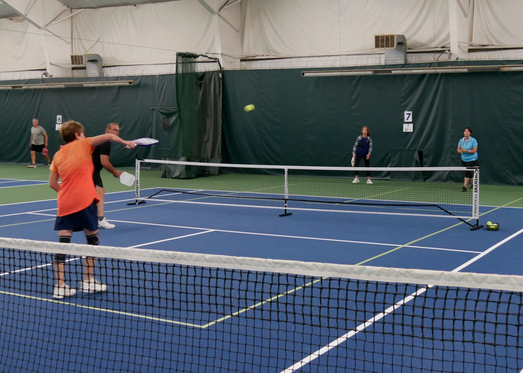 Pickleball doubles teams playing.