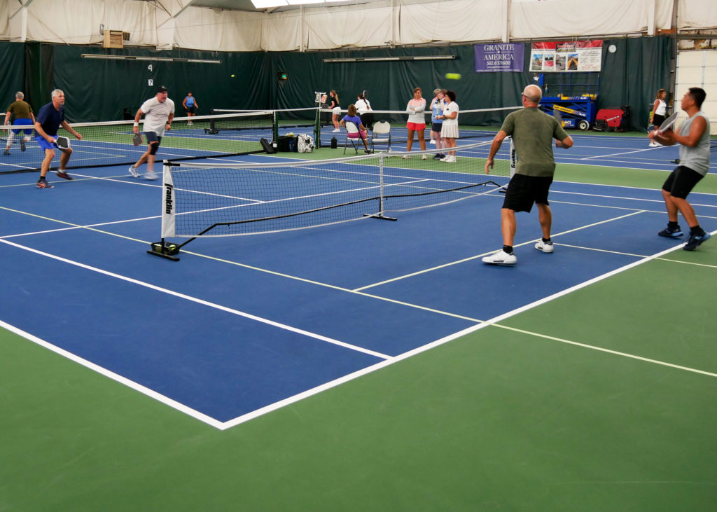 Pickleball doubles teams playing.