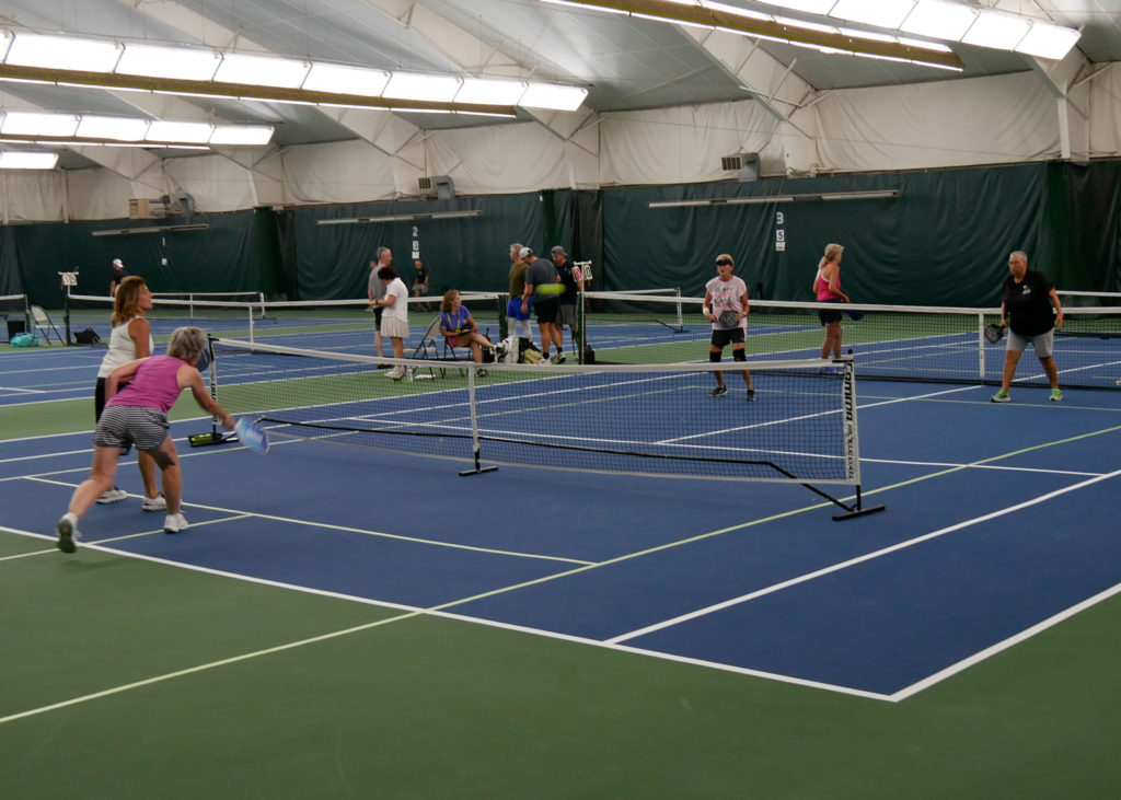 Pickleball doubles teams playing.