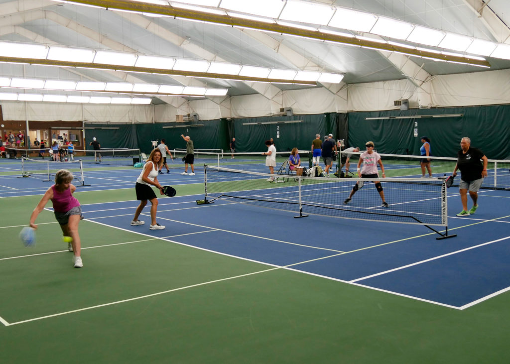 Pickleball doubles teams playing.