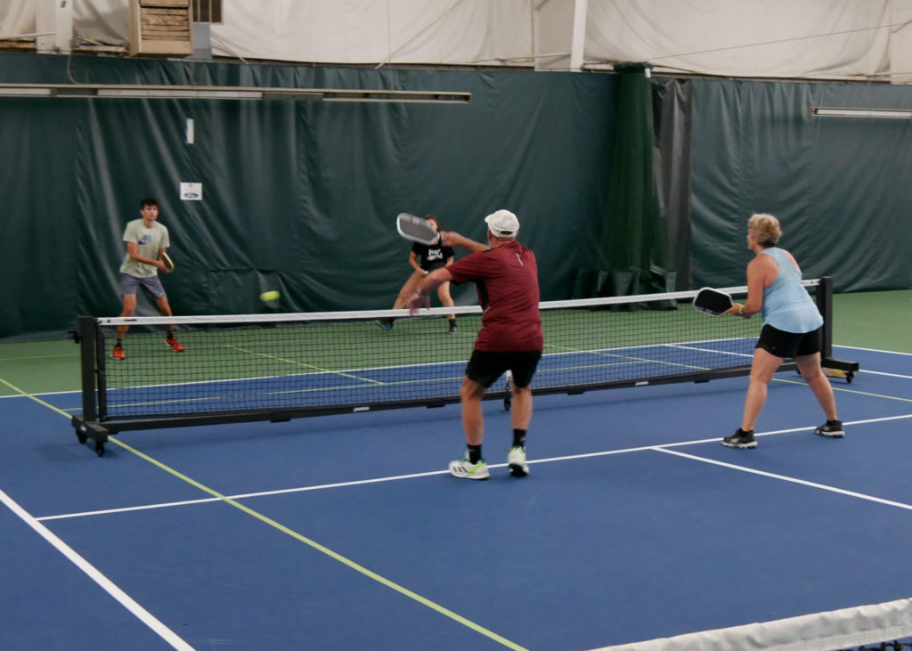 Pickleball doubles teams playing.