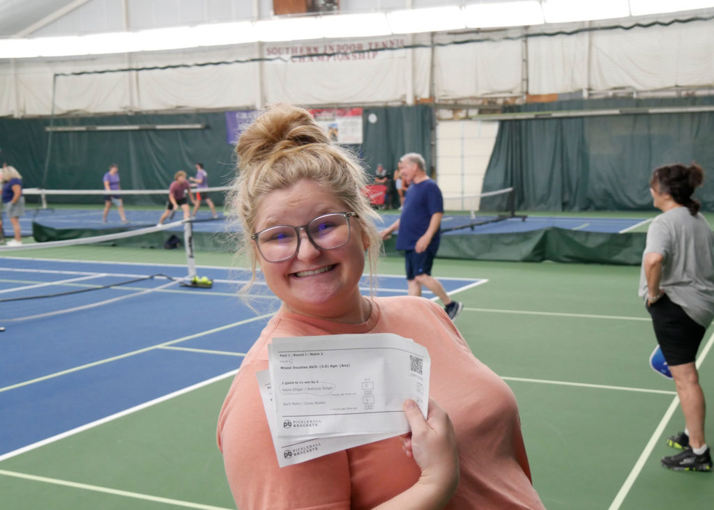 Justine Aycock, Director of Development, flashes scores and smiles.