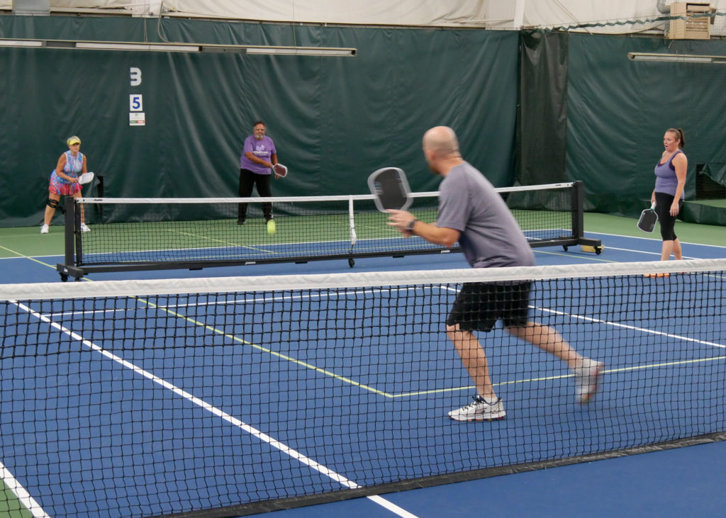 Pickleball doubles teams playing.
