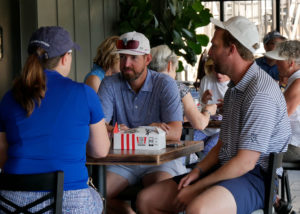 Two men and one woman enjoying the KFC box lunches before the golf scramble begins.
