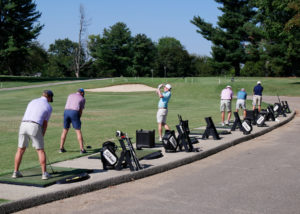 A group of men at the driving range before the golf scramble begins.