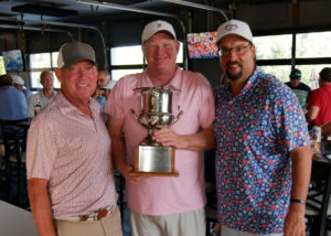 Doug Voss and team pose for a photo with the golf trophy.