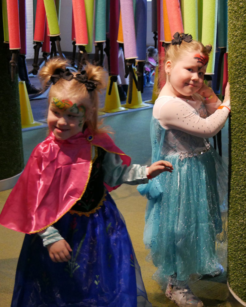 Two girls pause chasing each other through the hanging pool noodles at the Kentucky Science Center.