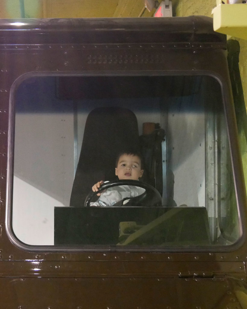 A small boy peeks over the steering wheel of the UPS truck parked in the Kentucky Science Center.
