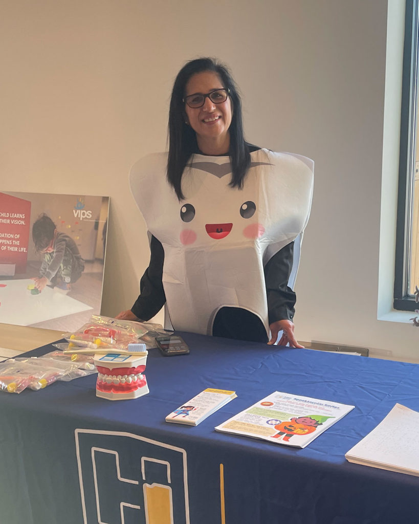 A woman representing the Oral Health Division of the Indiana Department of Health and wearing a tooth costume poses for a photo behind their table at the FRC.