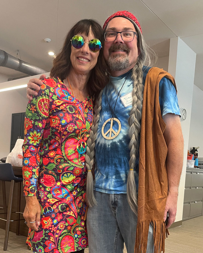 Rita DeVore and David Sterne pose for a photo in their hippie costumes.