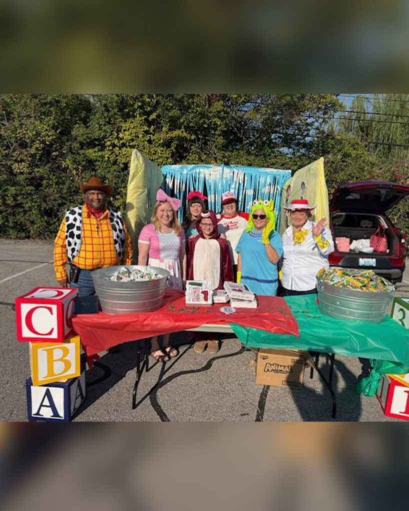 Baptist Health volunteers pose for a photo with their Toy Story display.