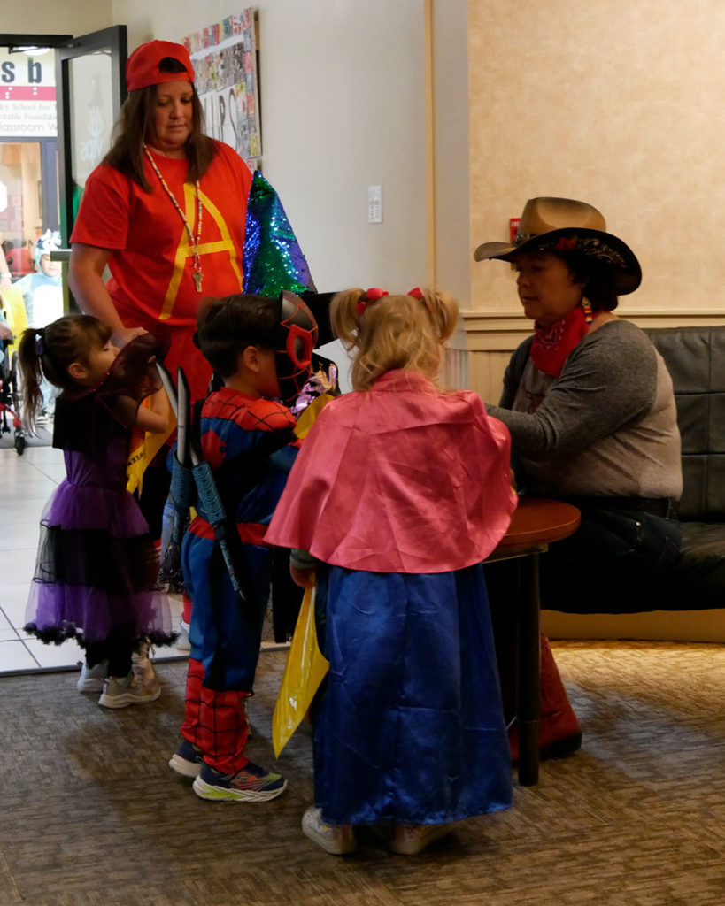 Spiderman and two princesses stop at Cowgirl Kirsten's table for treats.