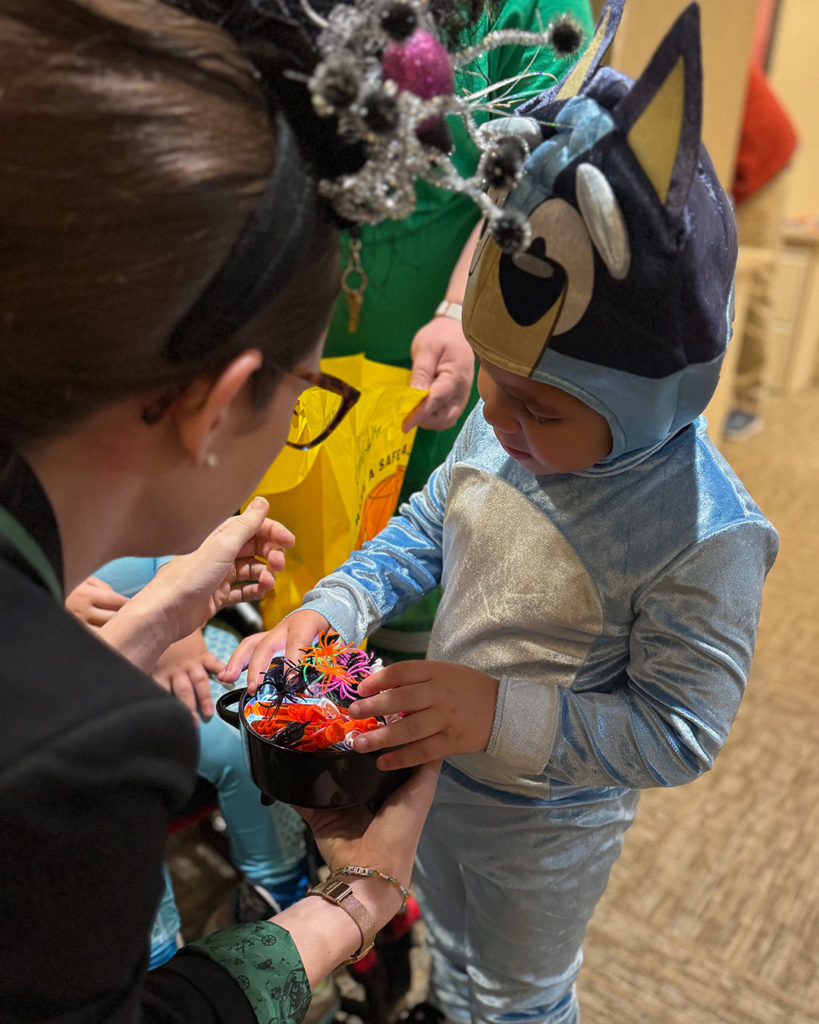 Bluey picks out a spider ring from Miss Paige's treat bowl.