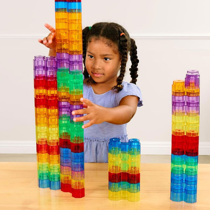 A young girl playing with a set of Excellerations Translucent Rainbow Octagon Stackers.