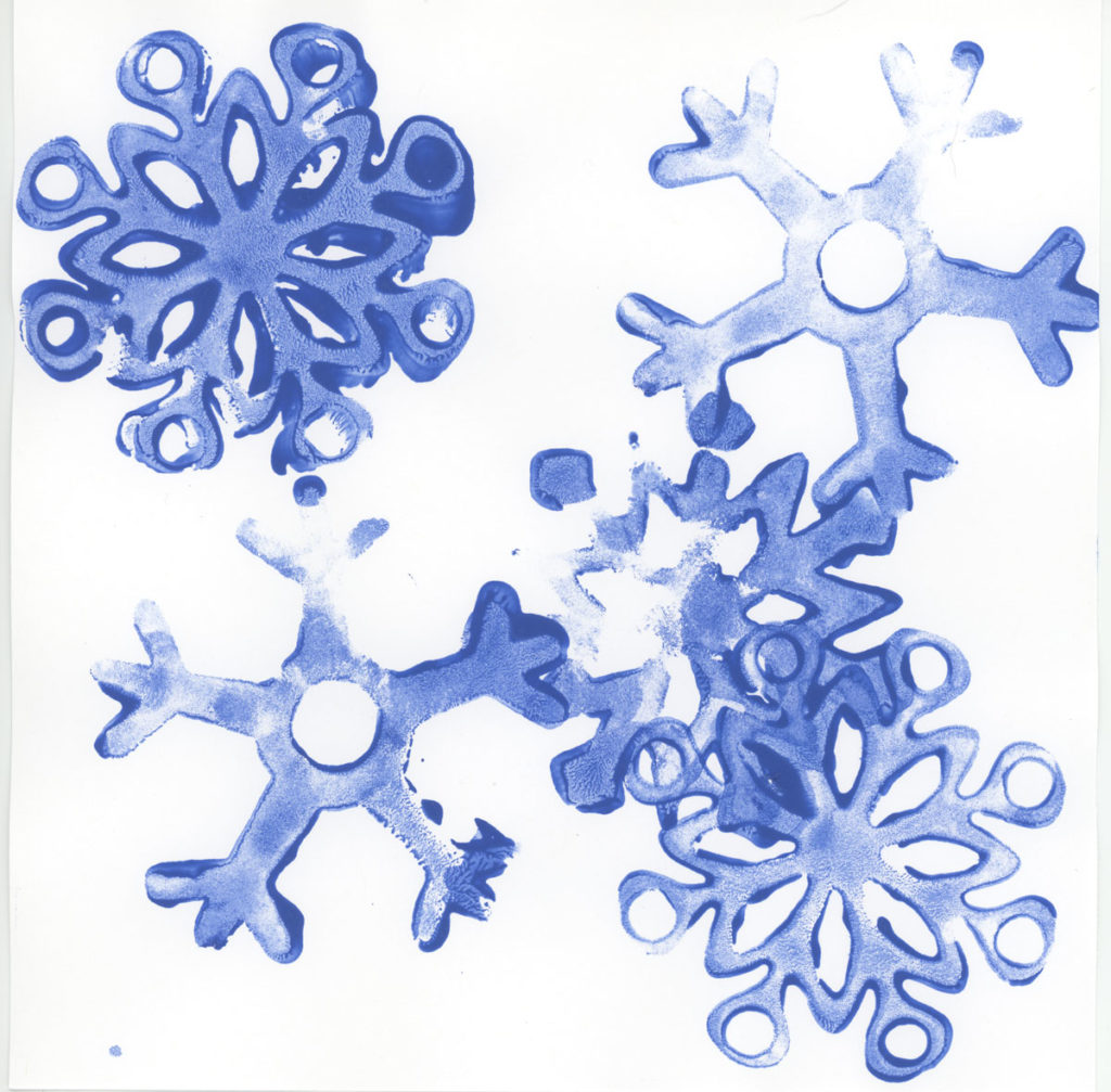 Child-made snowflakes created a shaped stamp and blue ink.