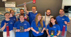 Volunteers from Forvis Mazars pose for a group photo with the birthday cards they made.