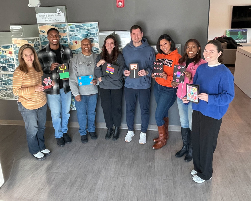 Volunteers from the NCAA PR team pose for a photo with the cards they made.