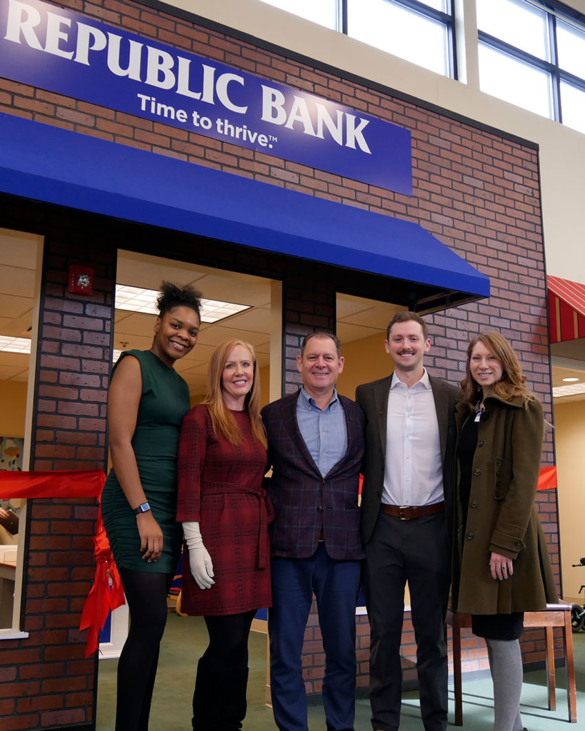 The team from Republic Bank poses for a photo in front of the new branch in Kids Town.