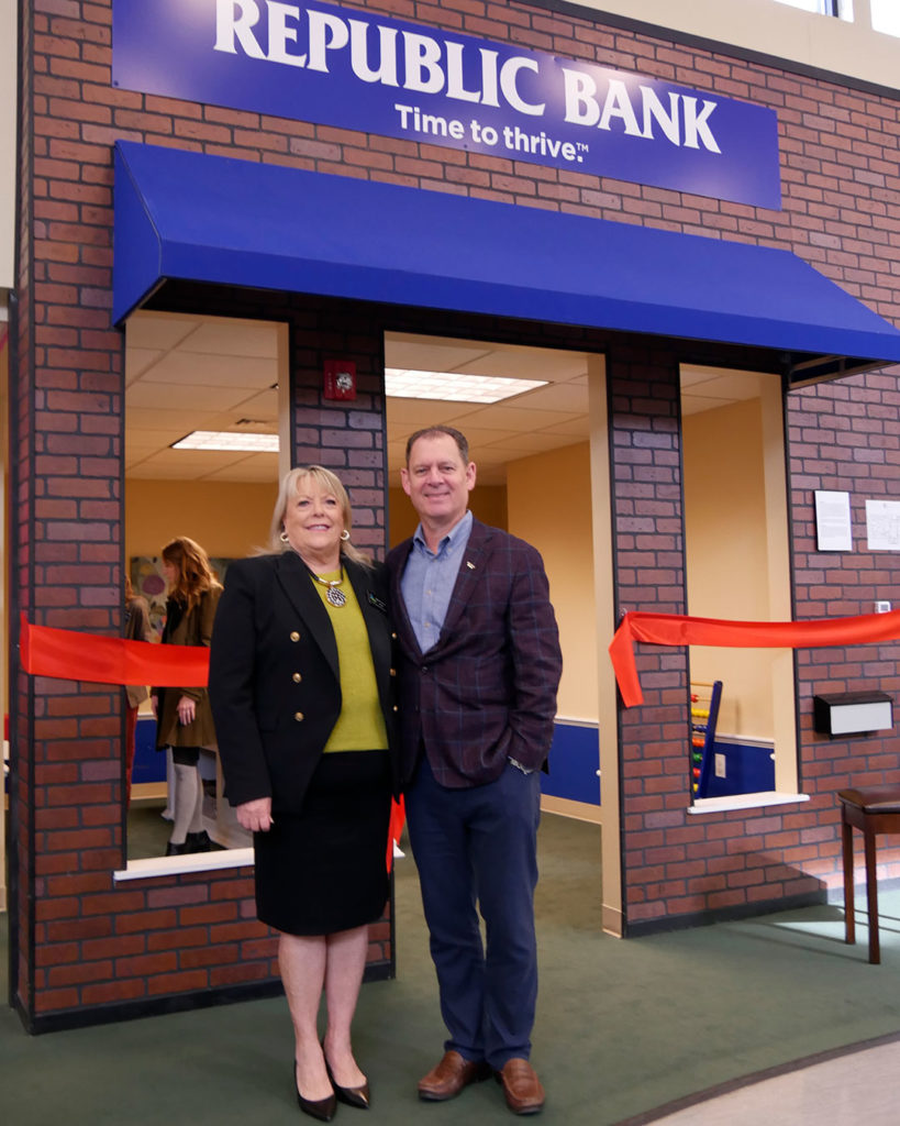 Diane Nelson, VIPS Executive Director, and Logan Pichel, Republic Bank President & CEO, pose for a photo in front of the Republic Bank branch in Kids Town.