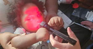 Kilani lies in her mother's lap and touches the red light she has been tracking.