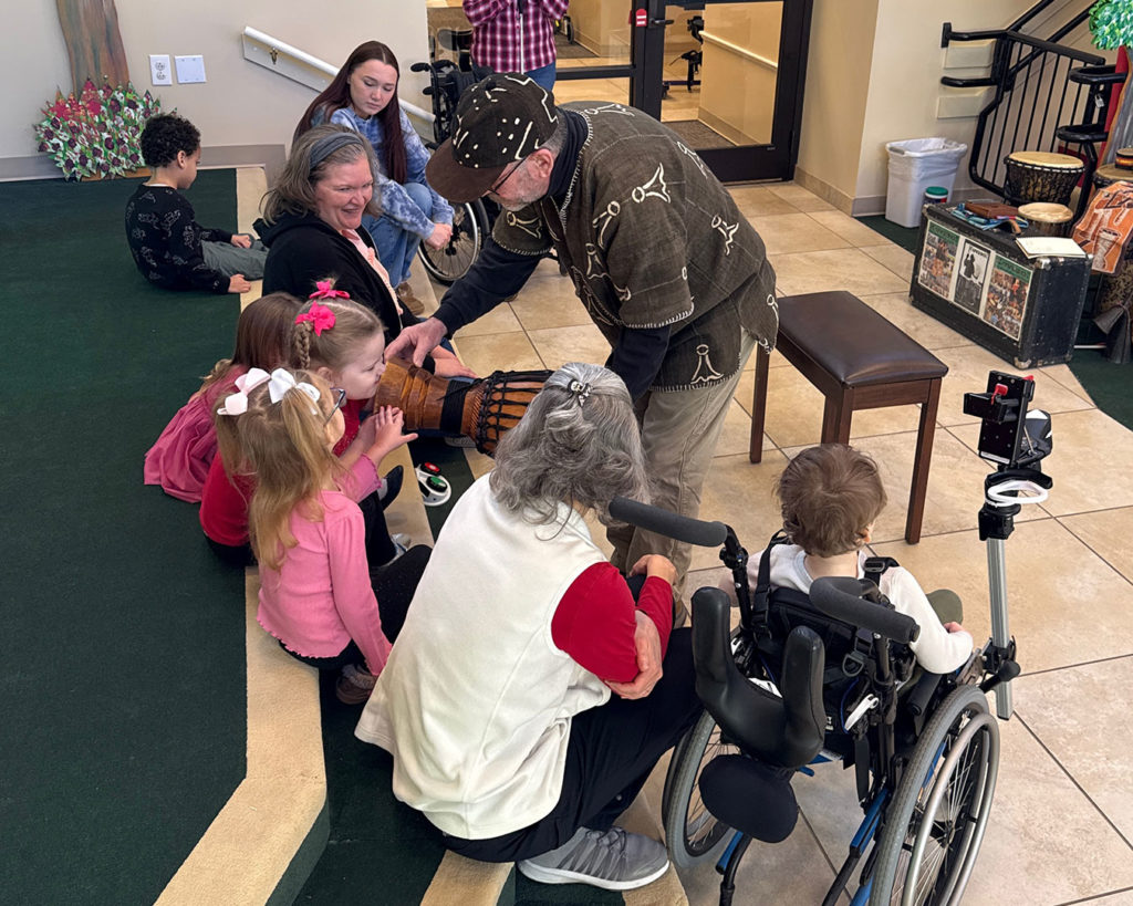Gregory shows the kids the parts of a drum.