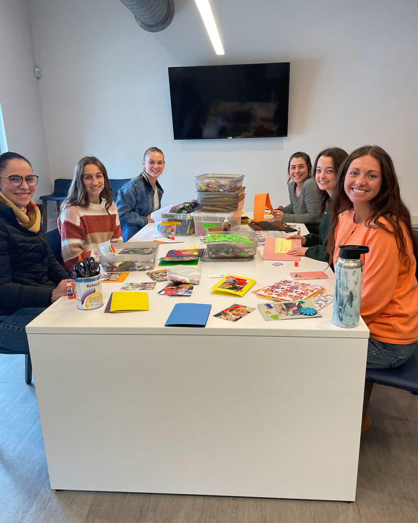 Volunteers from Mercy Road Church sit at the work table in the Family Resource Center and make cards.