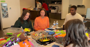 Volunteers from Mercy Road Church sit at the work table in the Family Resource Center and make cards.