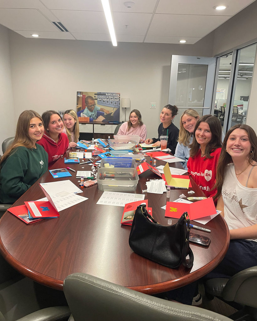 Delta Gammas sit around the conference table in the FRC and make cards.