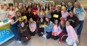 All the Delta Gammas pose for a group photo along with the cards they made.