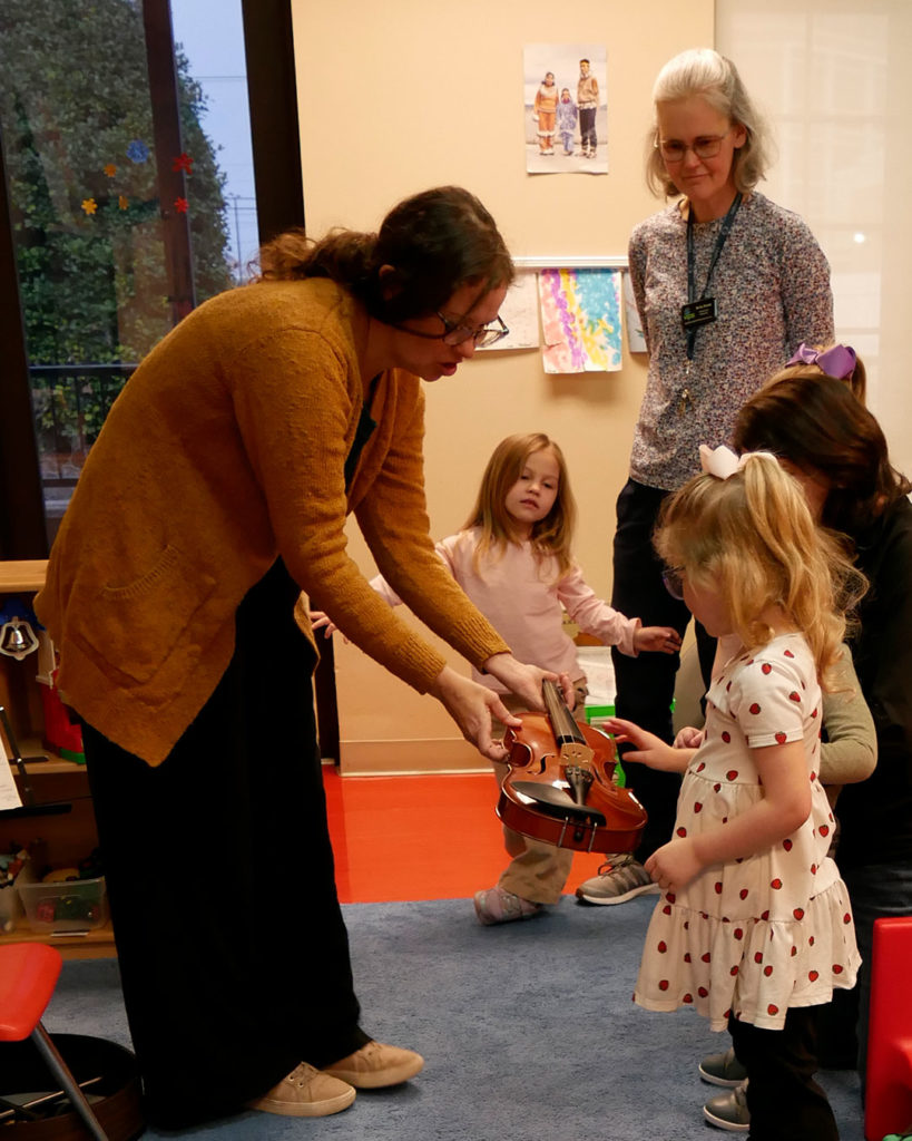The kids get to touch the fiddle and plucks it's strings.