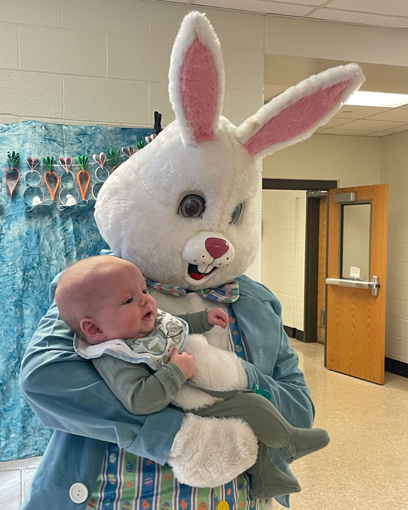The Easter Bunny poses for a photo with an infant.