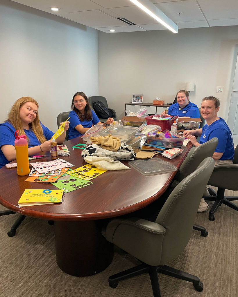 Volunteers from Forvis Mazars, LLP, make sensory books.