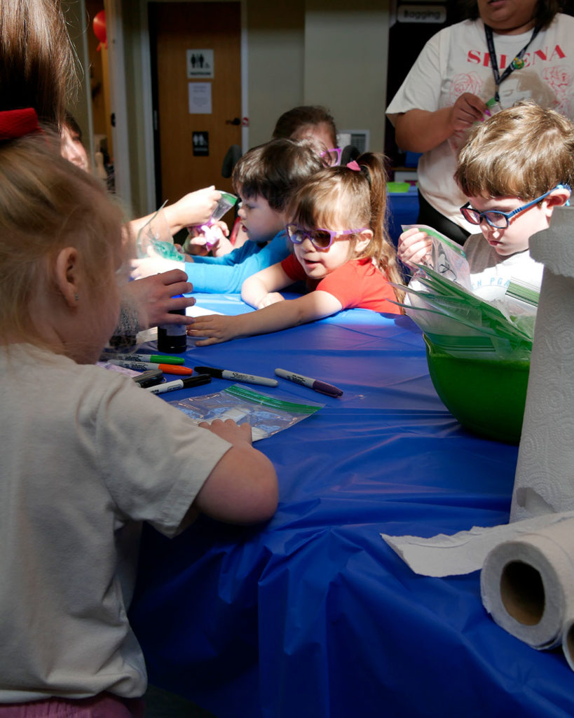 Kids are inspecting their bags of slime.