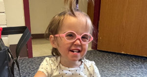Elise is sitting on the floor and playing with a shape sorter.