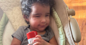 Ezra is holding a shaker tube and smiling.