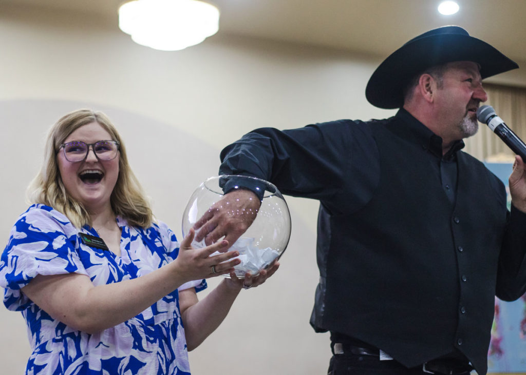 Auctioneer Shaun Logsdon pulls the Golden Ticket winning name from a fish bowl held by Justine Aycock.
