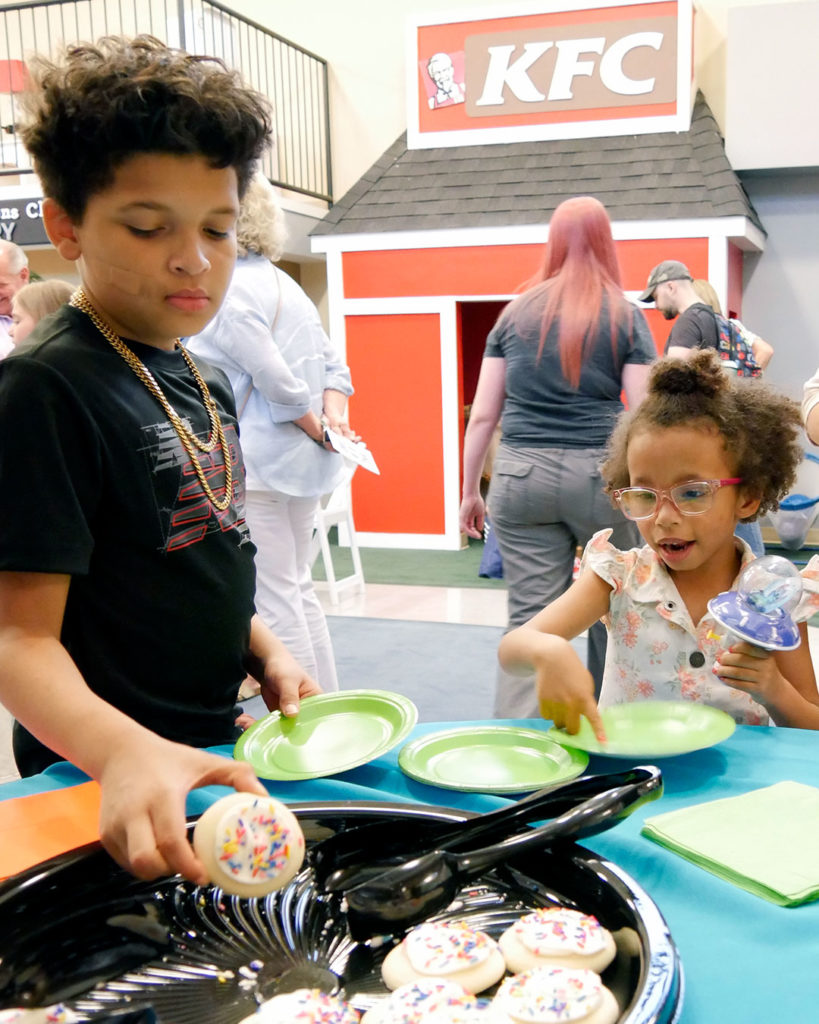 Kendall's big brother selects a cookie for her.