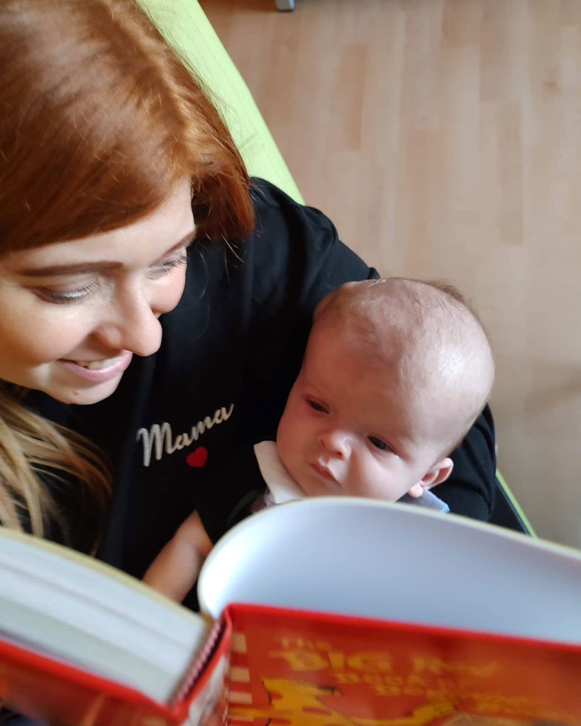 Kacey is holding Sonny and reading to him.